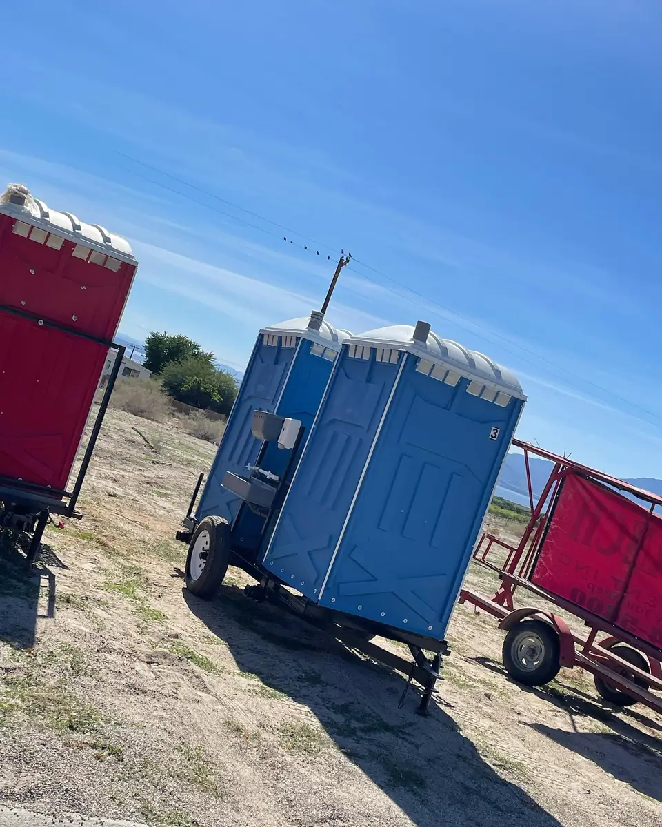 Porta potty strapped on a delivery trailer