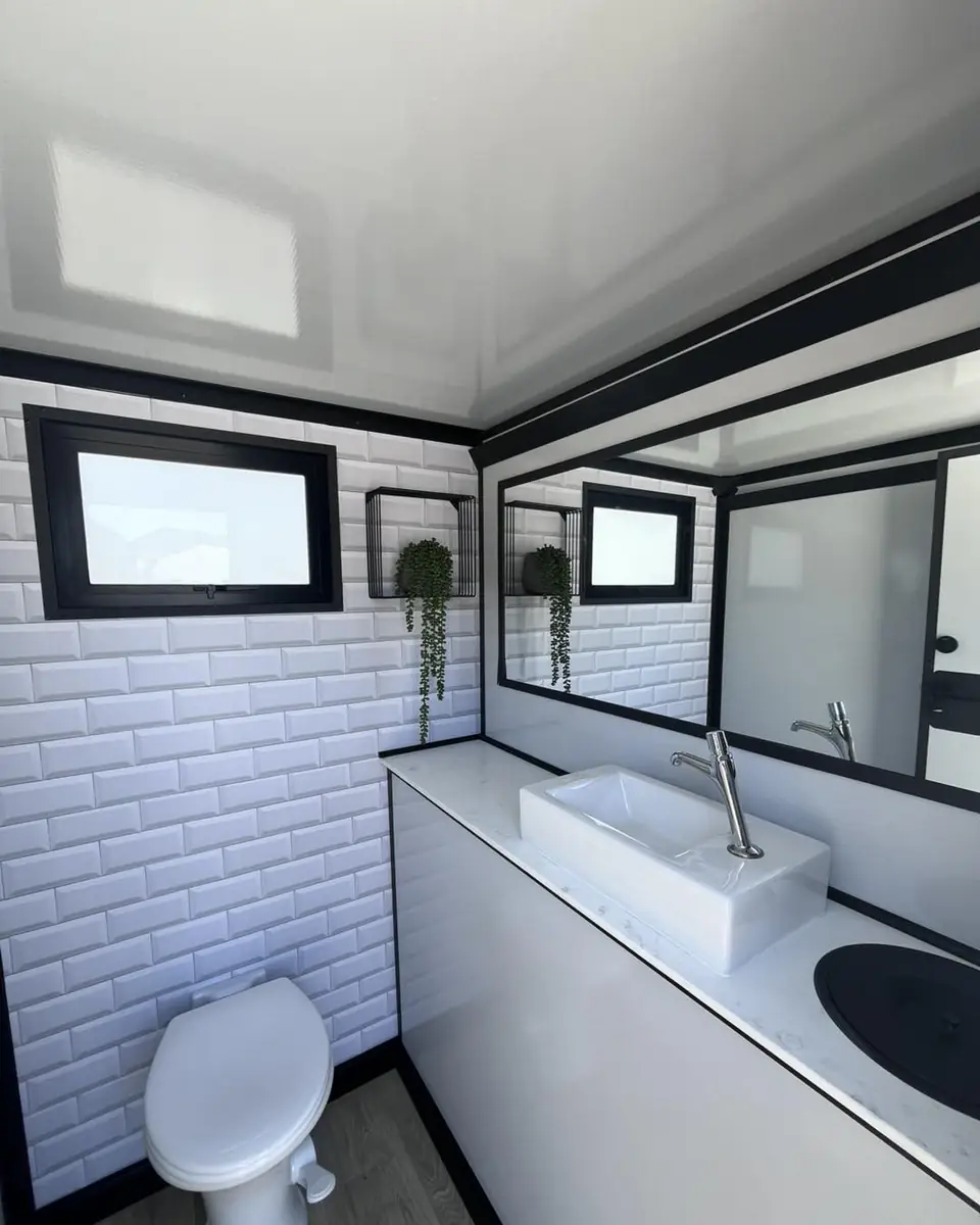 Bright restroom trailer stall with a sink and toilet