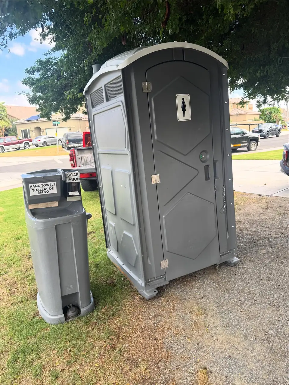 Standard porta potty with a hand-wash station on level grass for a Centralia event